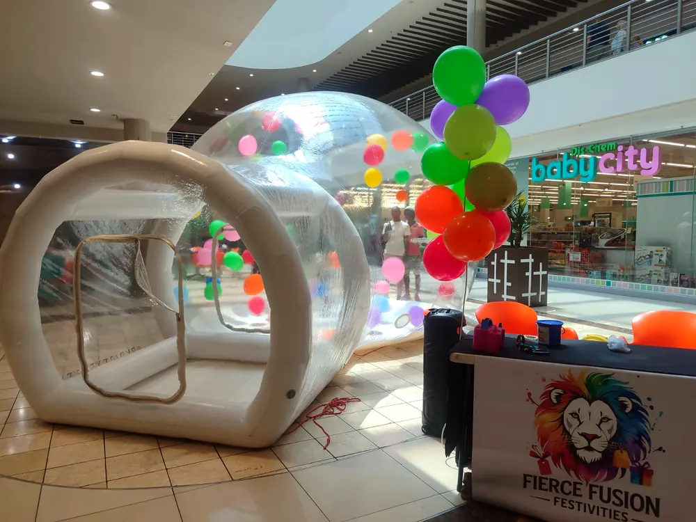 Bubble house in a shopping centre next to a Fierce Fusion Festivities branded stand and balloon bouquet