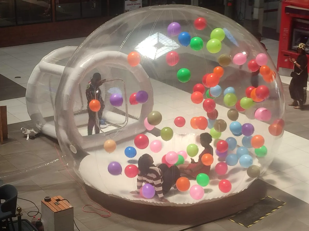 Kids playing among bright balloons inside a bubble dome at a shopping centre