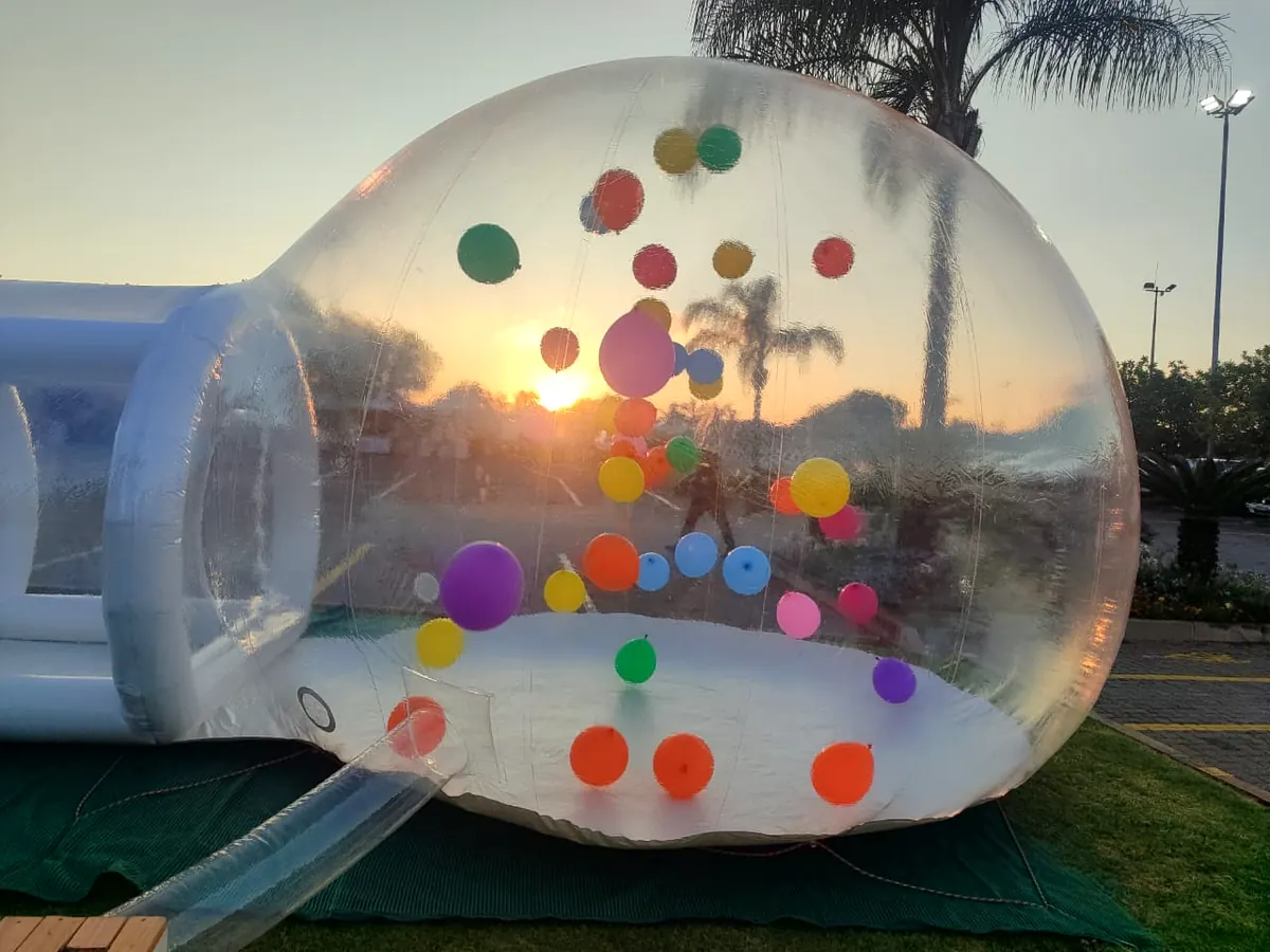 Bubble dome glowing at sunset with colourful balloons inside