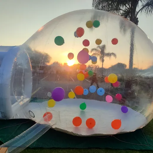 Balloon-filled bubble dome glowing at sunset