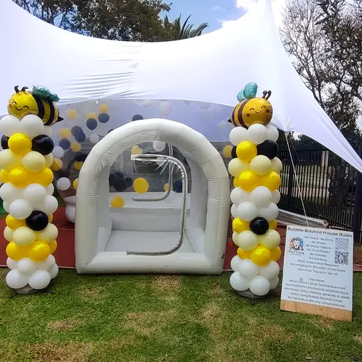 Bubble house entrance under a white stretch tent with balloon pillars