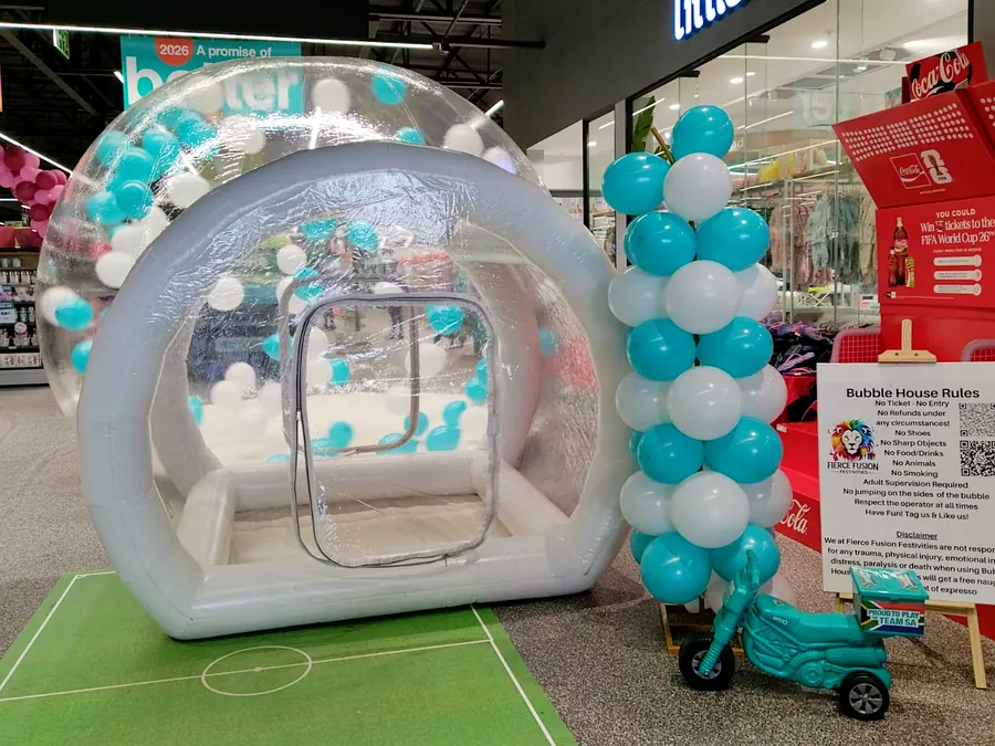 Fierce Fusion bubble house with teal and white balloons and a balloon pillar, set up in a shopping centre
